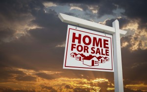 White and Red Home For Sale Real Estate Sign Over Beautiful Clouds and Sunset Sky.